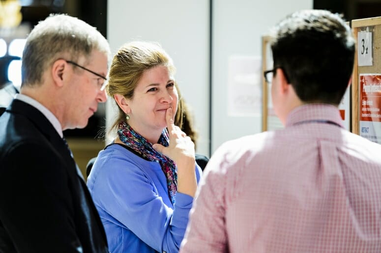 Steven Cramer, UW-Madison vice provost for teaching and learning, and Michelle Harris, faculty associate in the Biology Core Curriculum, listen to Evan Hernandez talk about his research project