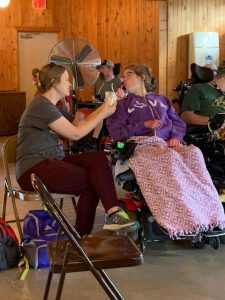 woman asssiting another woman who is seated in a wheelchair