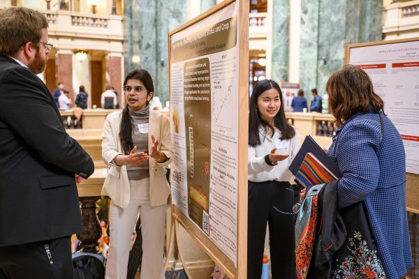 Second from left, graduate student Taqudeer Gill, explains how hyperspectral imagery and machine learning can lead to more sustainable, profitable snap bean farming in Wisconsin while her neighbor, civil and environmental engineering graduate student Ziyan Wu describes her poster about the detection of microplastics in lake water during the Graduate Research Showcase held in the Wisconsin State Capitol rotunda during the UW–Madison's Day at the Capitol, a University of Wisconsin–Madison advocacy and outreach event held for legislators and staff on April 26, 2023. “Wisconsin is the top producer of snap beans since it produced 44% of the US snap beans last year,” noted Gill. “In the long term, if farmers will not apply excessive nitrogen and the nitrate leaching will reduce and farmers will not be compromising on the crop yield.” (Photo by Althea Dotzour / UW–Madison)