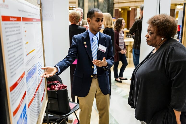 UW-Madison student Negassi Tesfamichael describes his research project on display to Gloria Hawkins, assistant vice provost and director of Chancellor's Scholars and Powers Knapp's Scholarship Programs