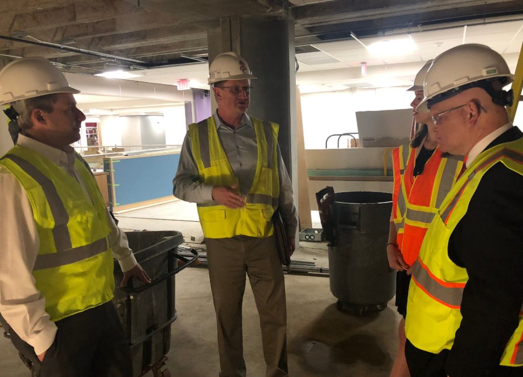 Three men talking in hard hats