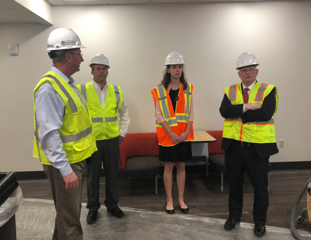Three men one woman in hard hats