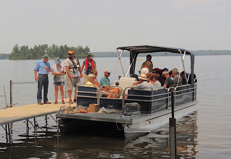 pontoon boat and indivduals near a dock
