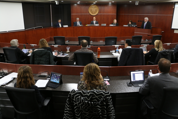 Group of people siting in a formal council chambers room